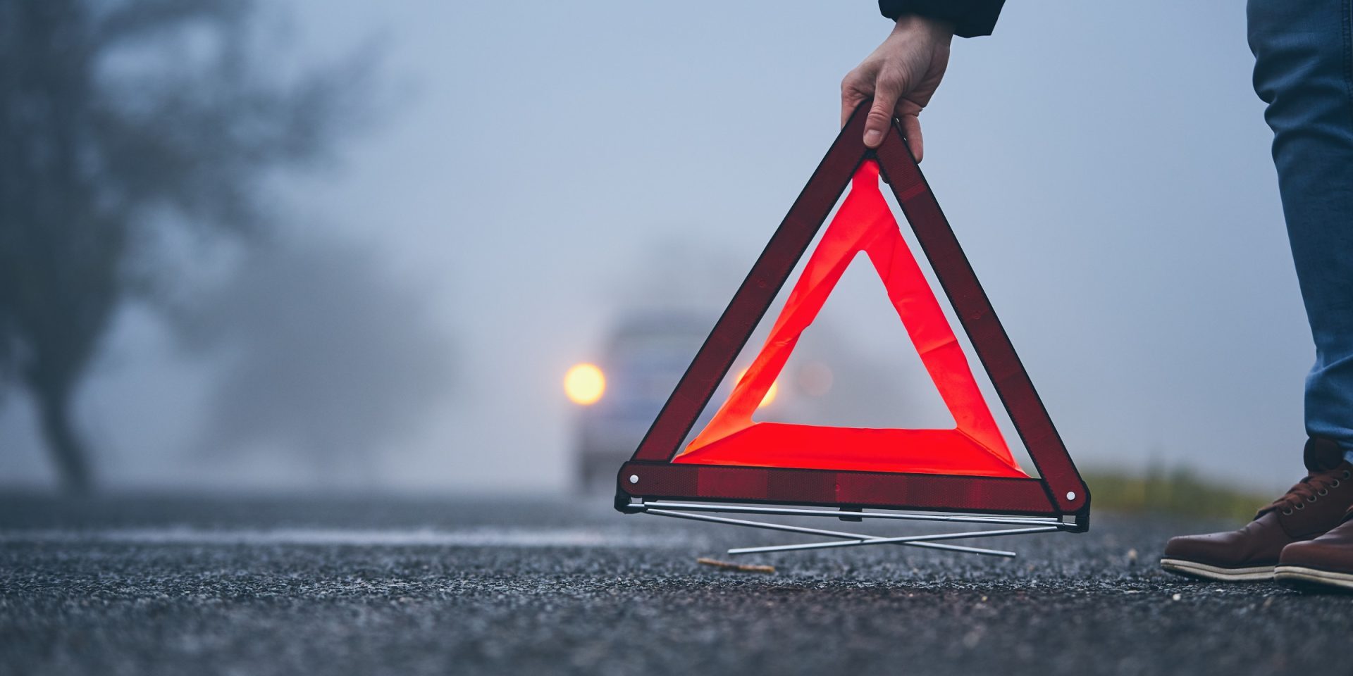 IranPride-warning A hand is dropping a Warning triangle on the road